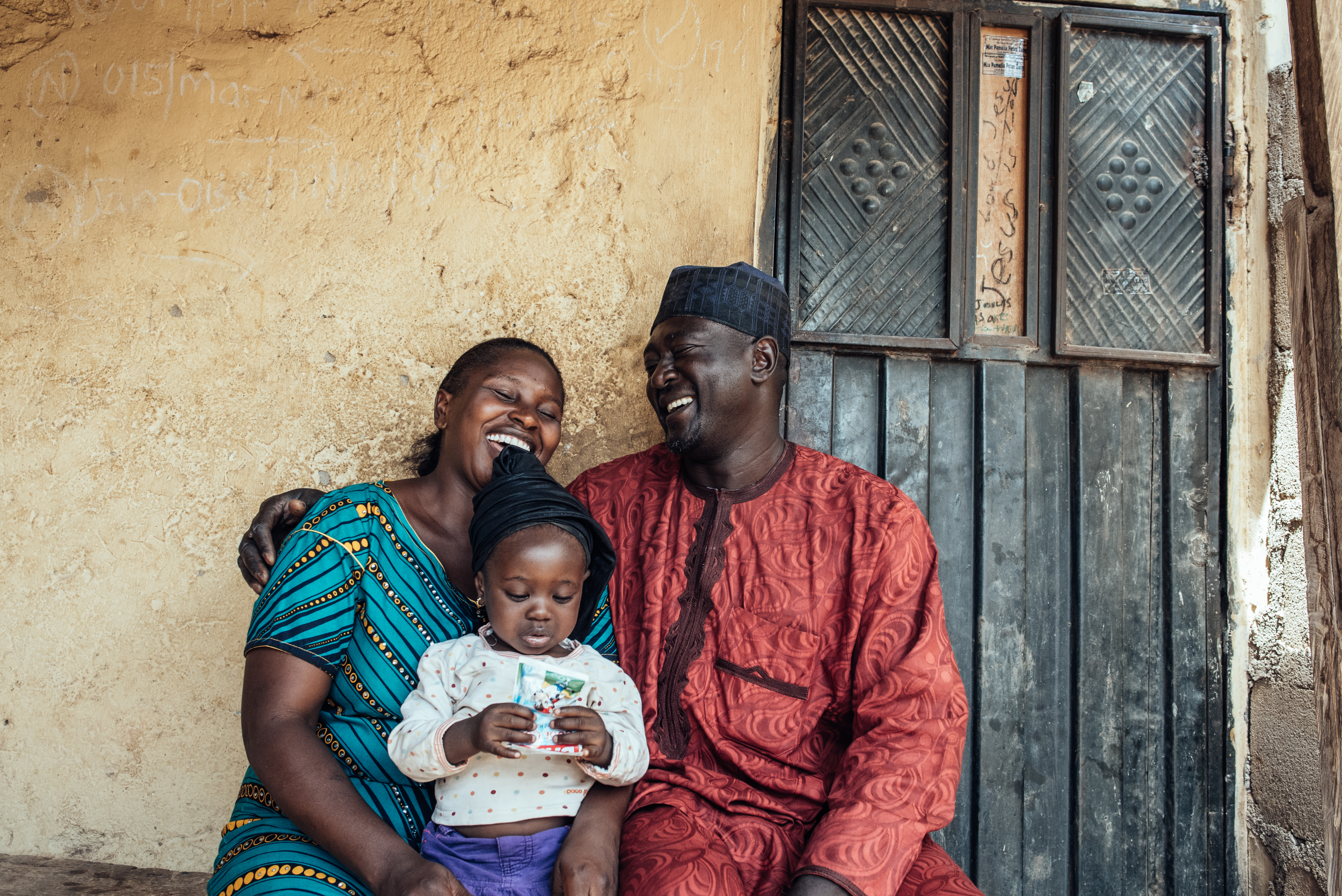 A man and a woman smiling with their child